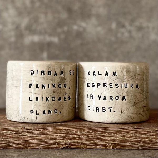 A set of small mugs with words in Lithuanian