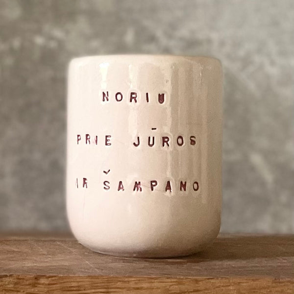 Small pink mug without handle with text in Lithuanian