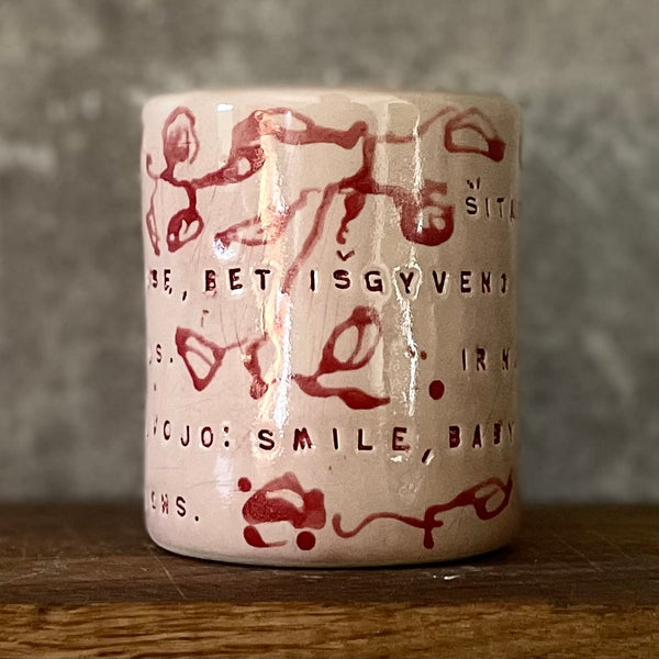 Rausvas gėlėtas puodelis su ilgu tekstu