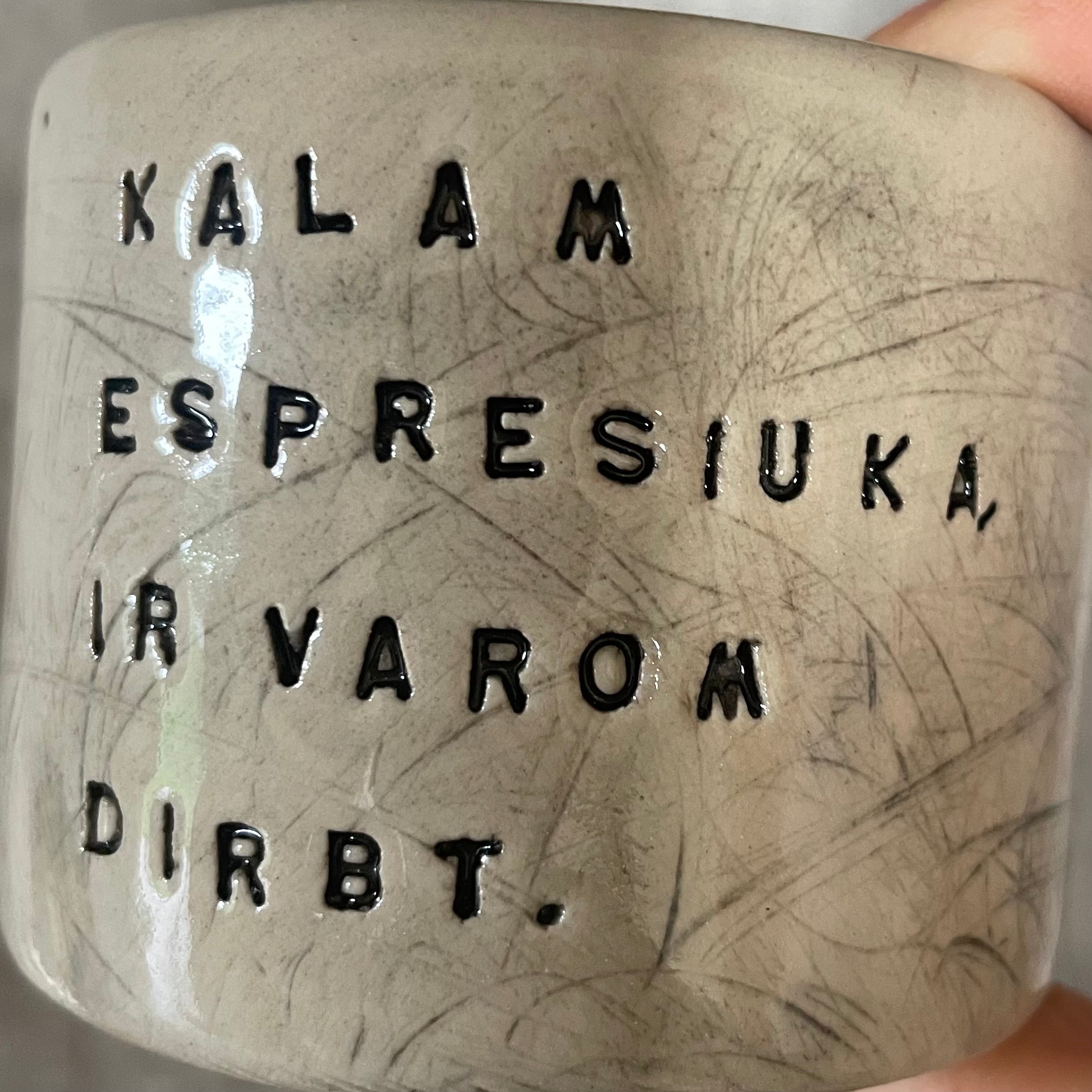 A set of small mugs with words in Lithuanian