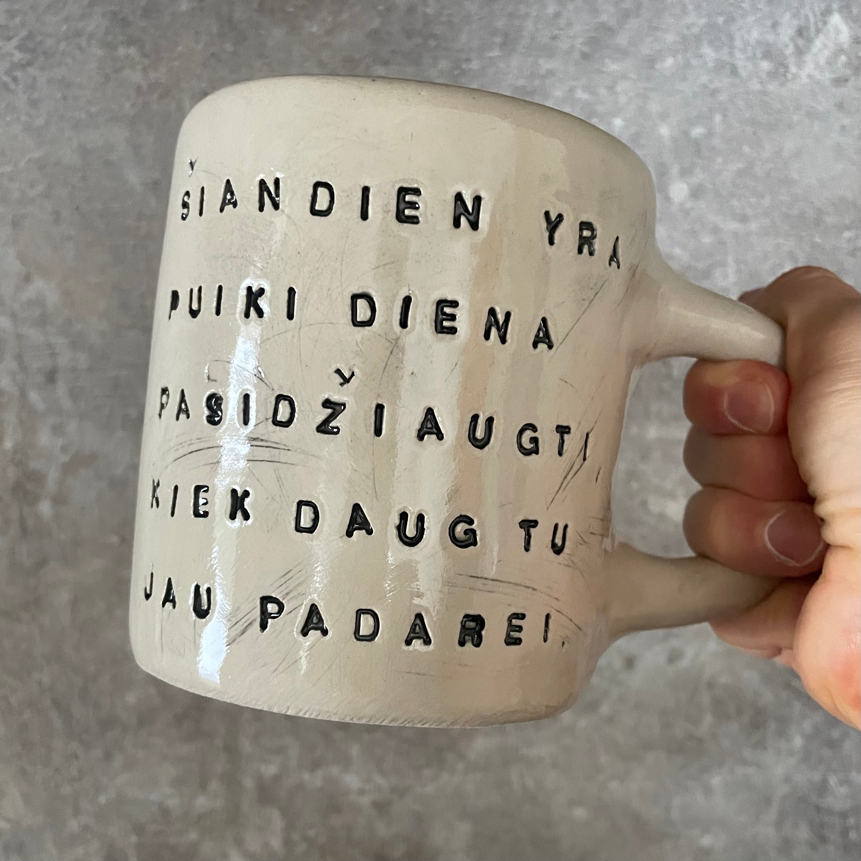 Puodelis su optimistiniu užrašu