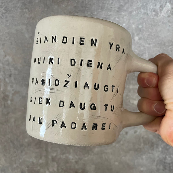Puodelis su optimistiniu užrašu