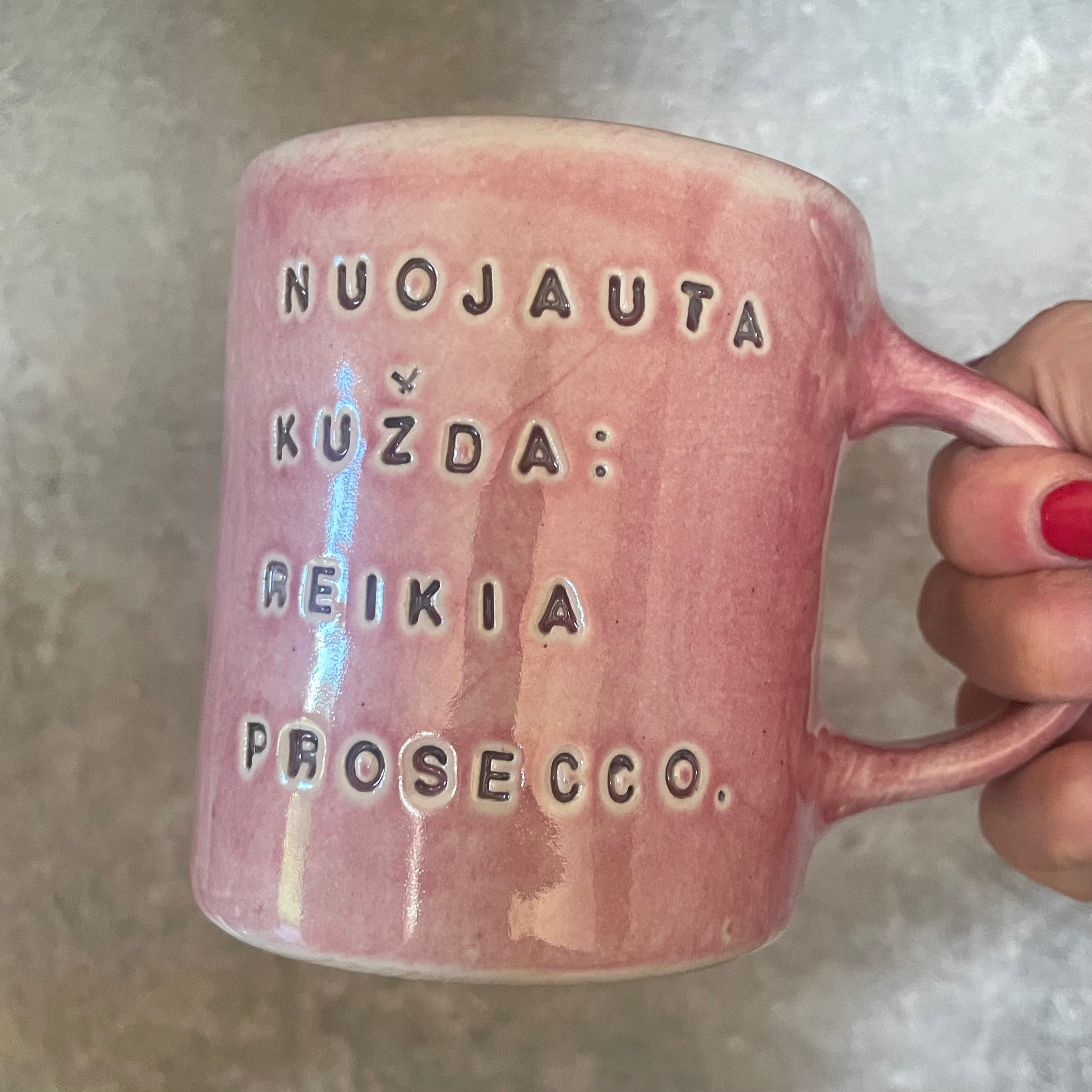 Puodelis su linksmu užrašu apie prosecco