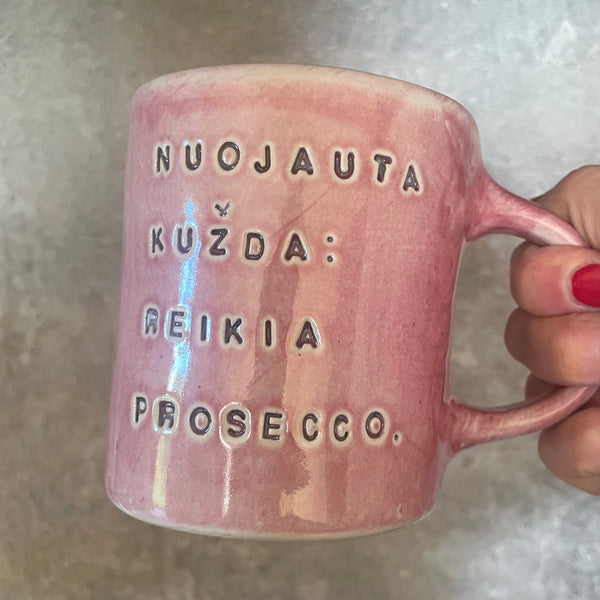 Puodelis su linksmu užrašu apie prosecco