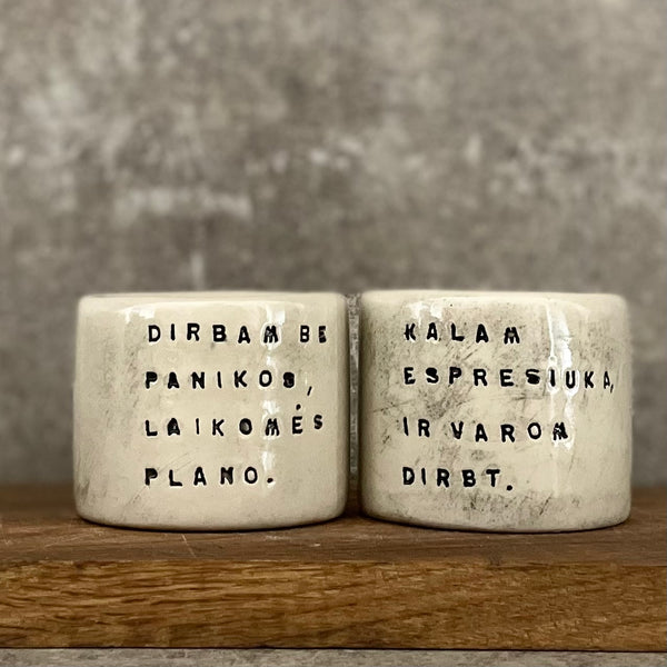 A set of small mugs with words in Lithuanian