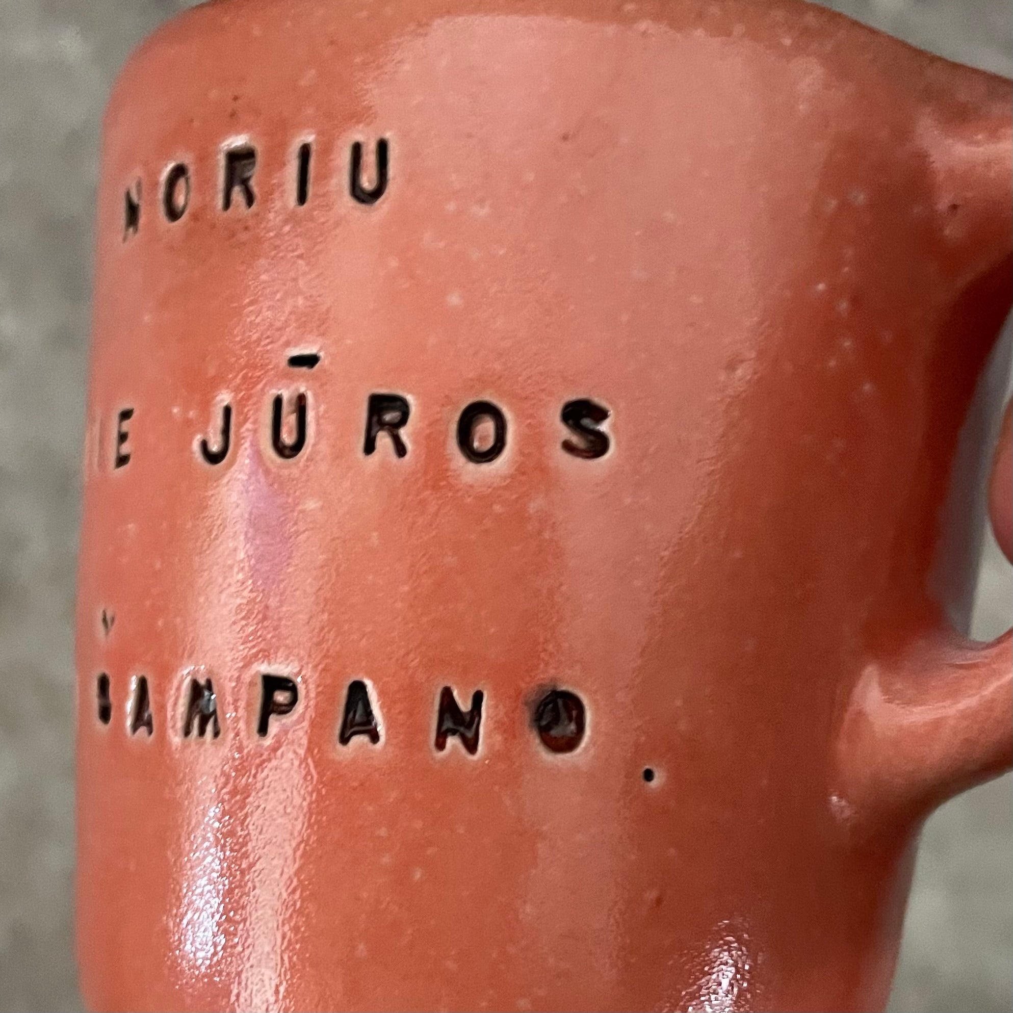 Small red mug with words in Lithuanian