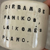 A set of small mugs with words in Lithuanian