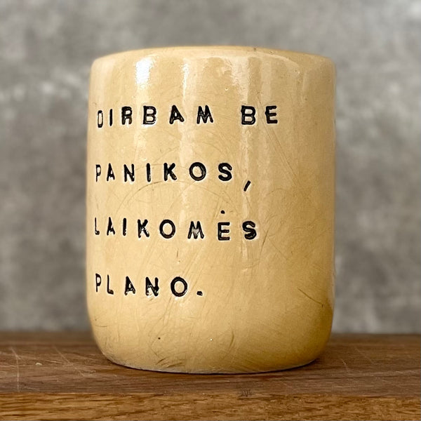 Geltonas didelis puodelis be rankenos su užrašu