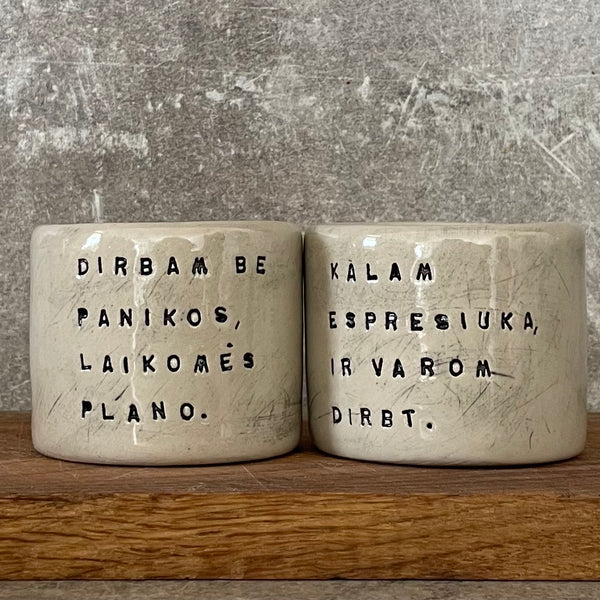 Du maži espresso puodeliai su tekstu apie darbą