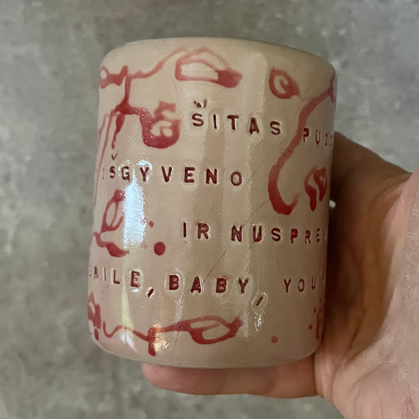 Rausvas gėlėtas puodelis su ilgu tekstu