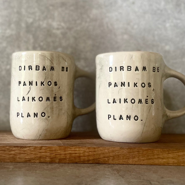 Two big ceramic mugs with words about work