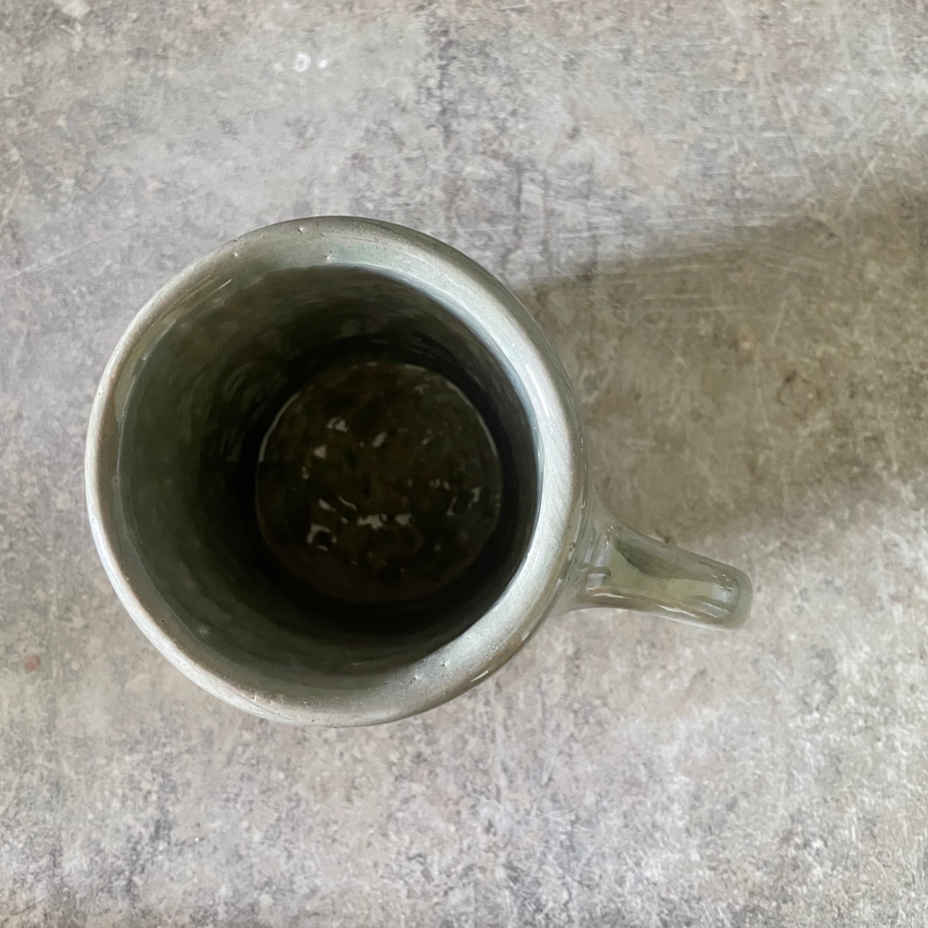 Green ceramic mug with words about work