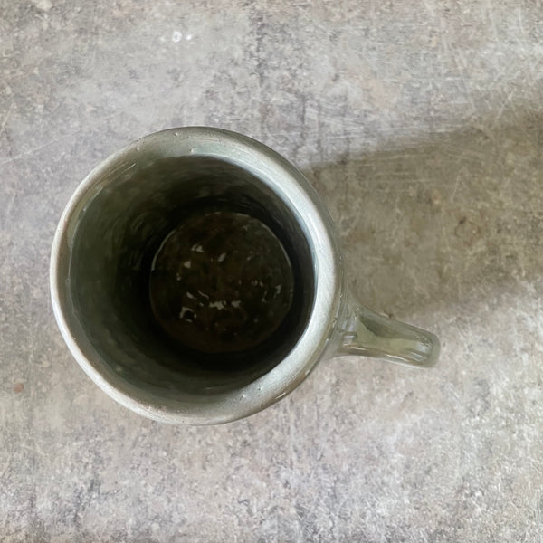 Green ceramic mug with words about work