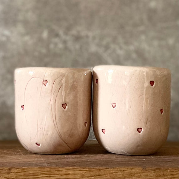 Du maži rožiniai puodeliai su širdelėmis