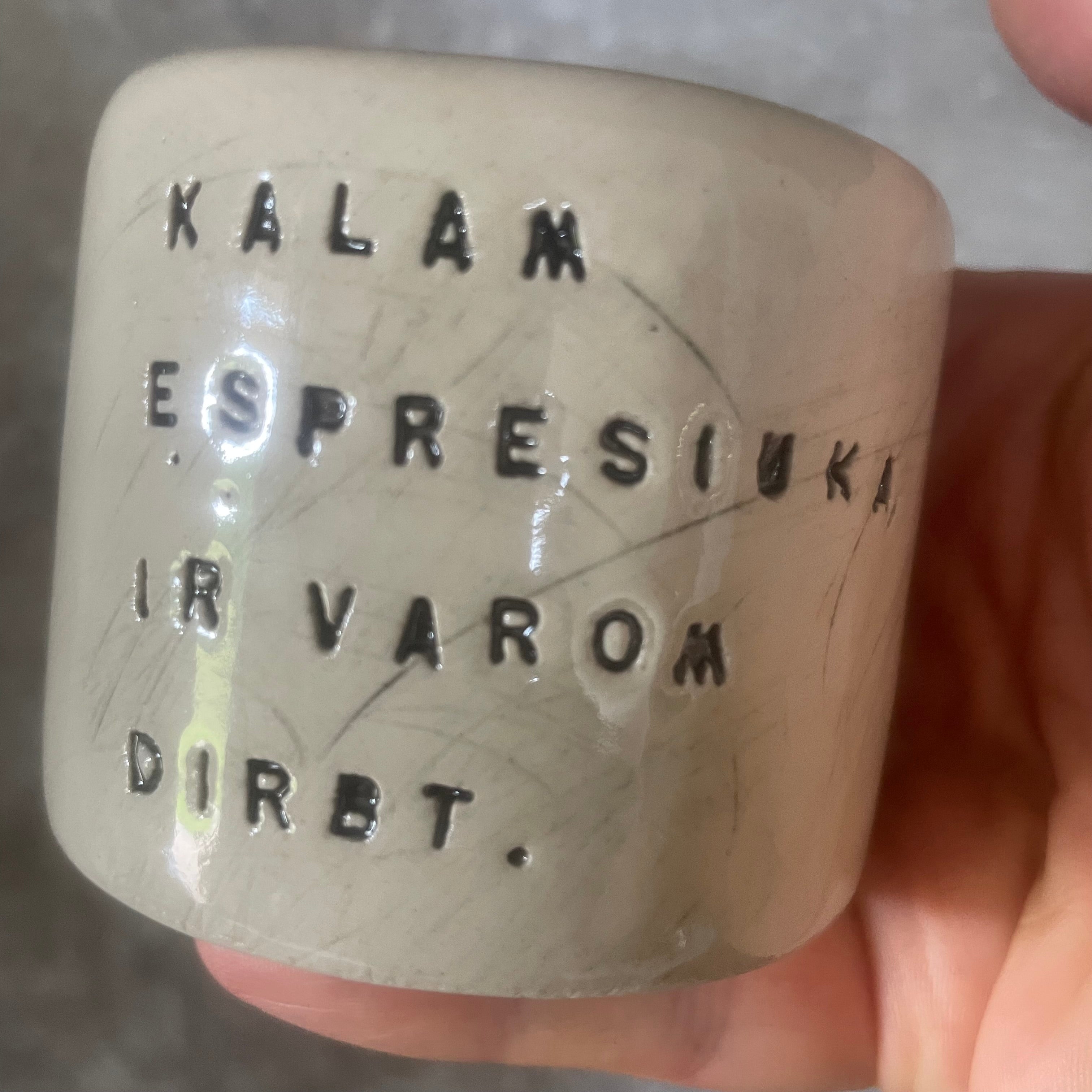 A set of small mugs with words in Lithuanian