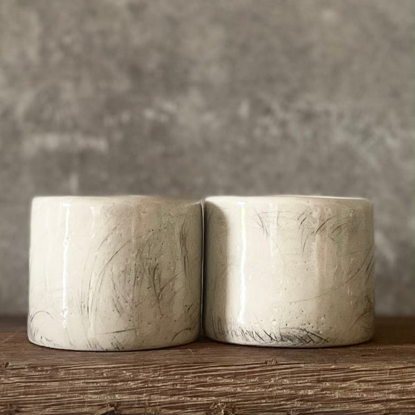 A set of small mugs with words in Lithuanian