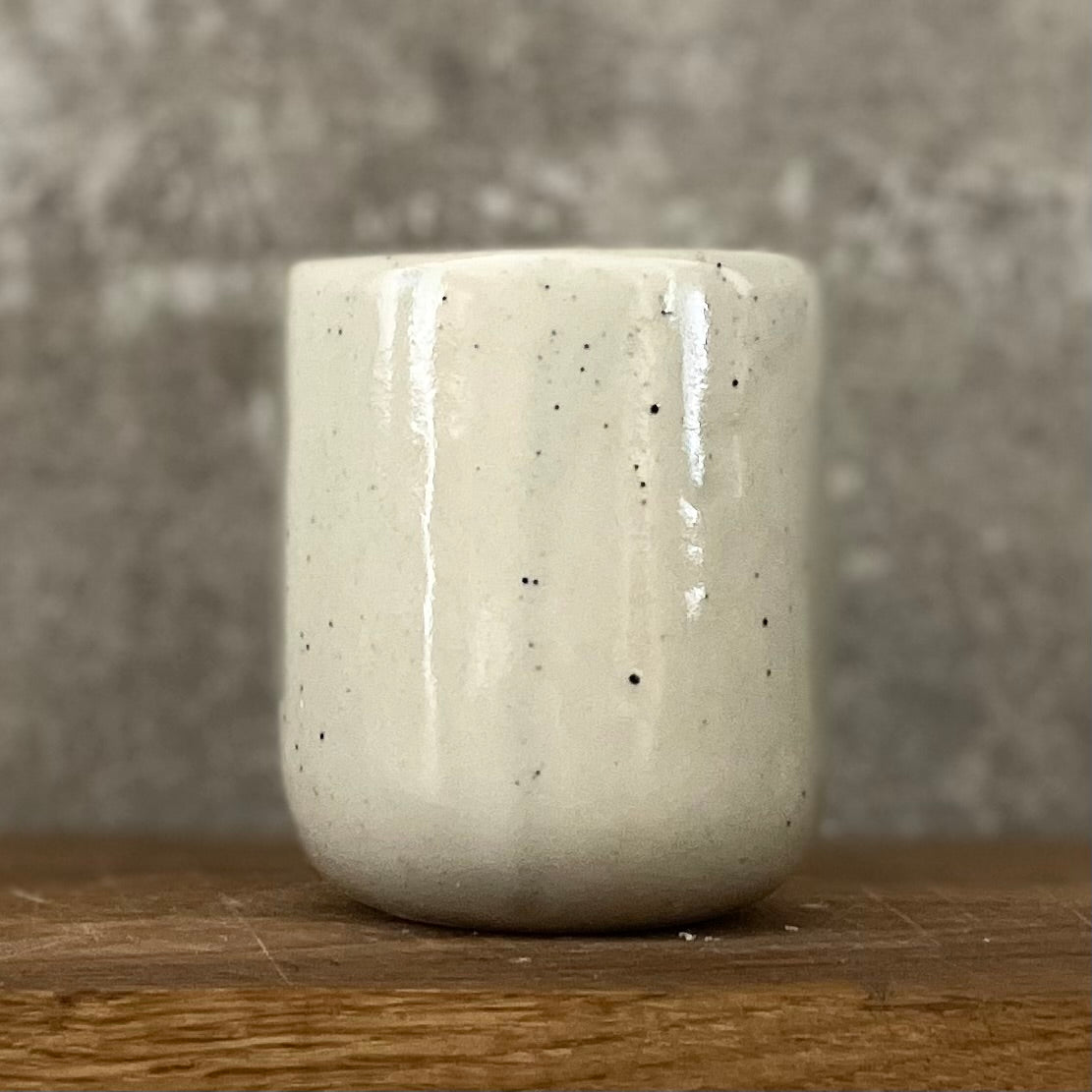 Small speckled mug without handle with text in Lithuanian