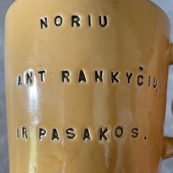 Geltonas puodelis su mielu užrašu