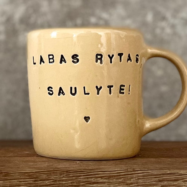Yellow cup with saying "LABAS RYTAS"