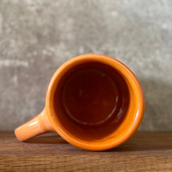 Oranžinis puodelis su afirmacija jam