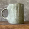Green ceramic mug with words about work