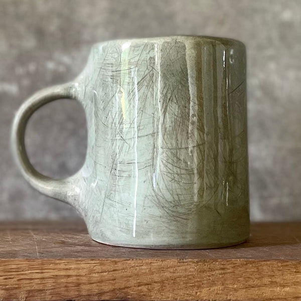 Green ceramic mug with words about work