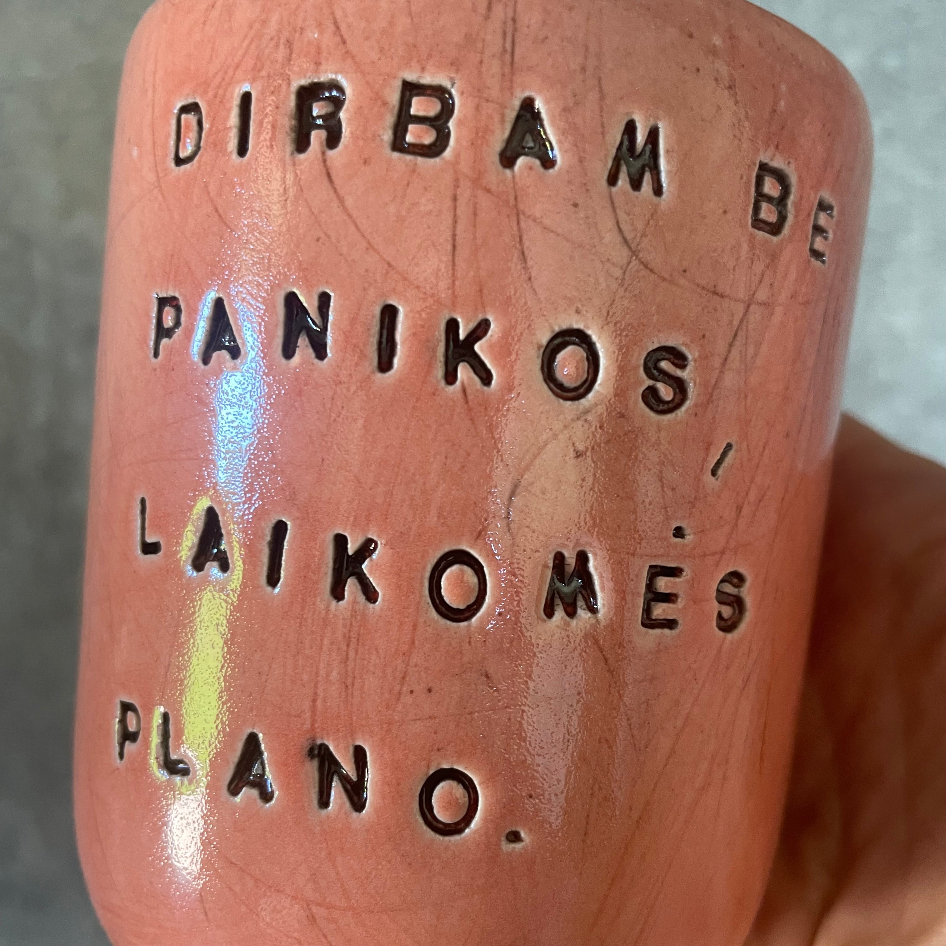 Raudonas didelis puodelis be rankenos su užrašu