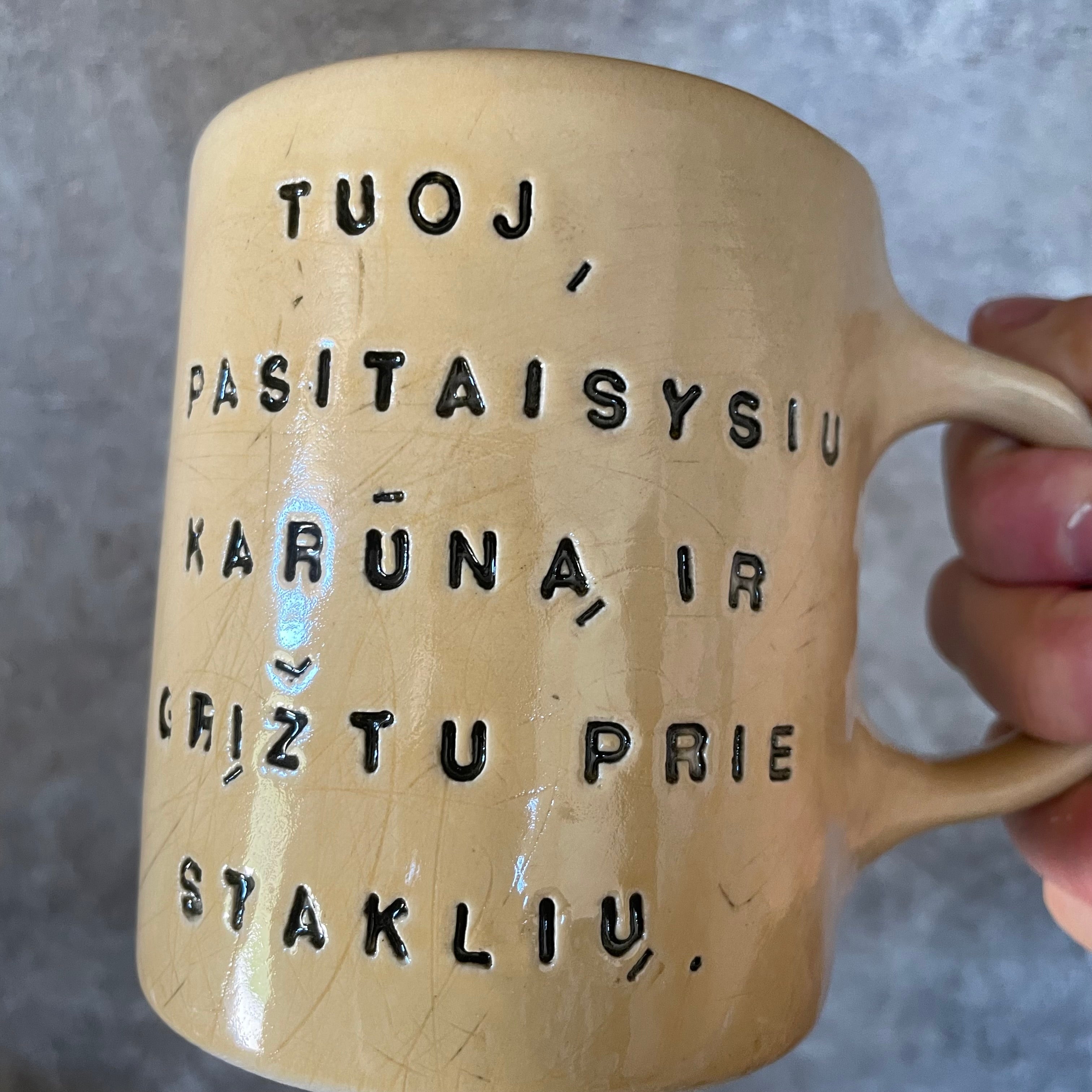 Geltonas puodelis su užrašu