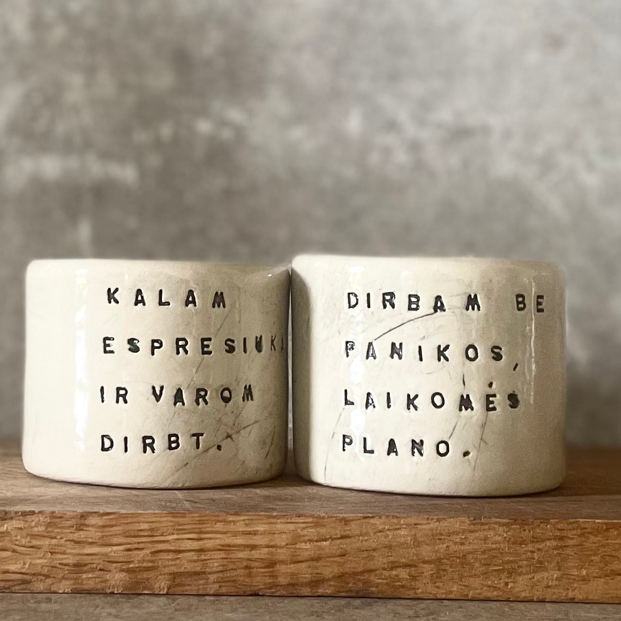 Du maži espresso puodeliai su tekstu apie darbą