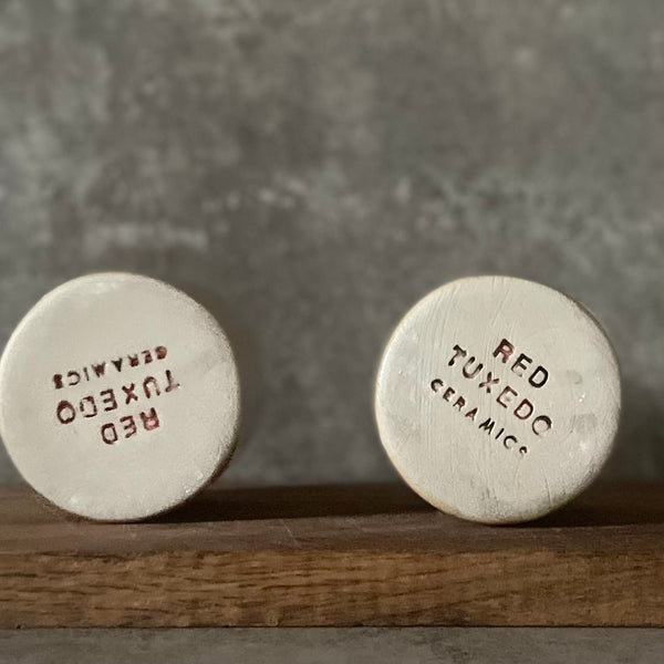 A pair of small mugs with words in Lithuanian