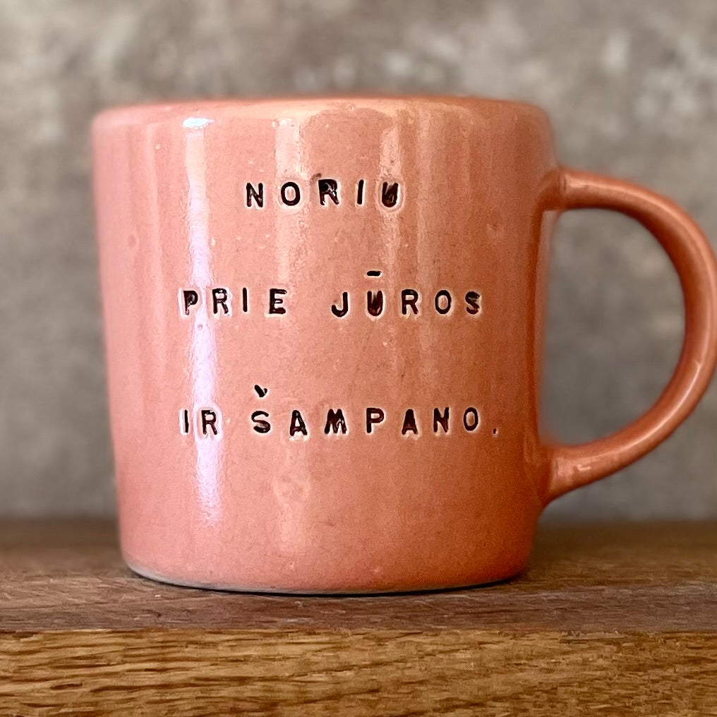 Puodelis su užrašu apie šampaną