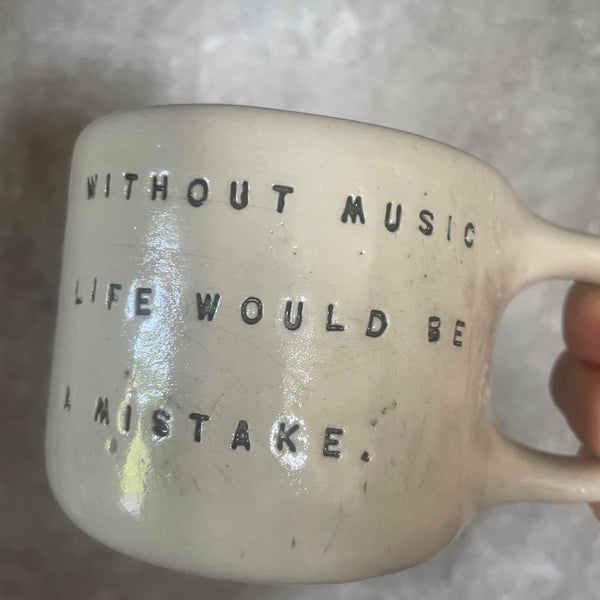 Puodelis su Nyčės citata apie muziką