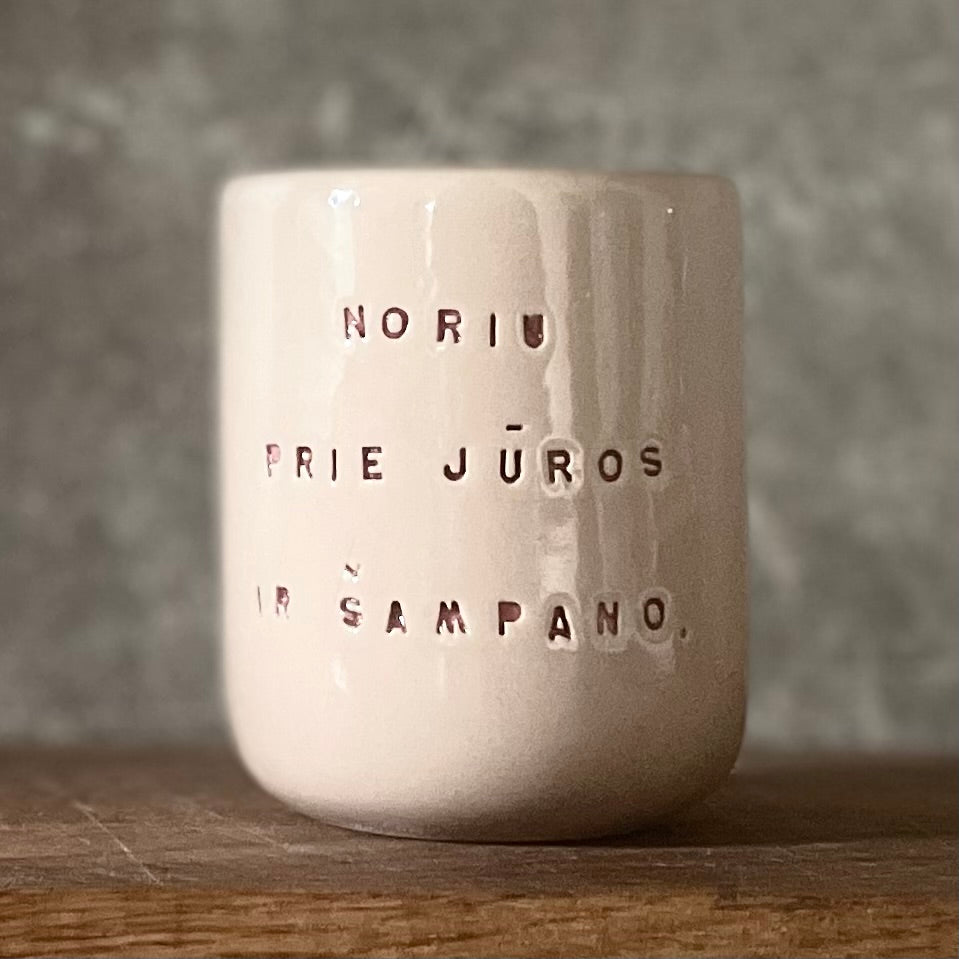 Small pink mug without handle with text in Lithuanian