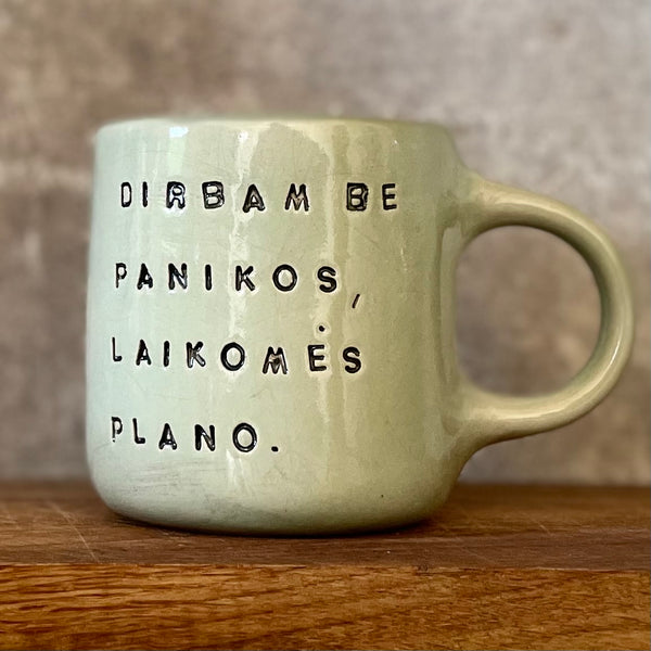 Greenish mug with words about work