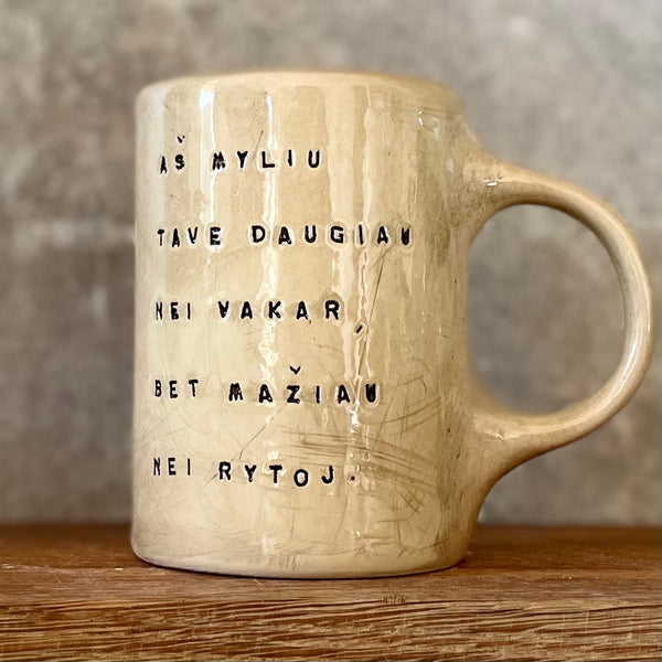 Rusvas puodelis su užrašu apie meilę