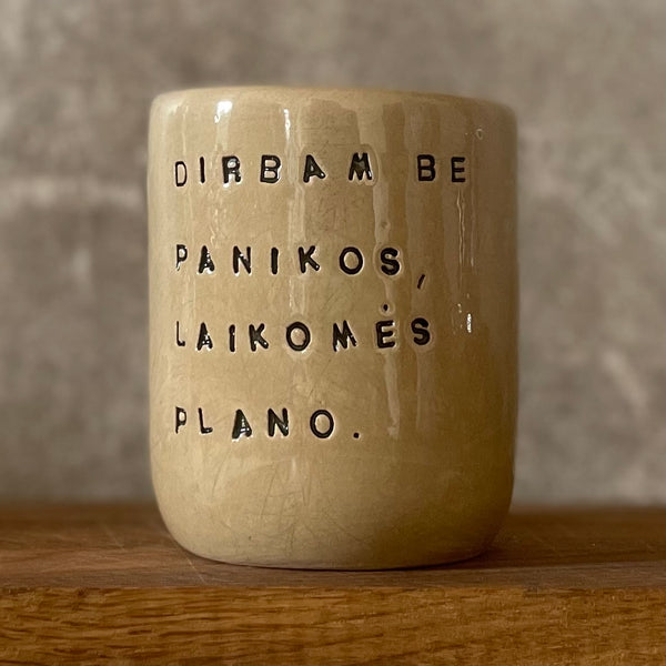 Rusvas didelis puodelis be rankenos su užrašu