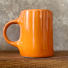 Oranžinis puodelis su afirmacija jam