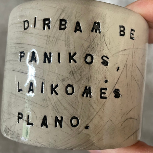 A set of small mugs with words in Lithuanian