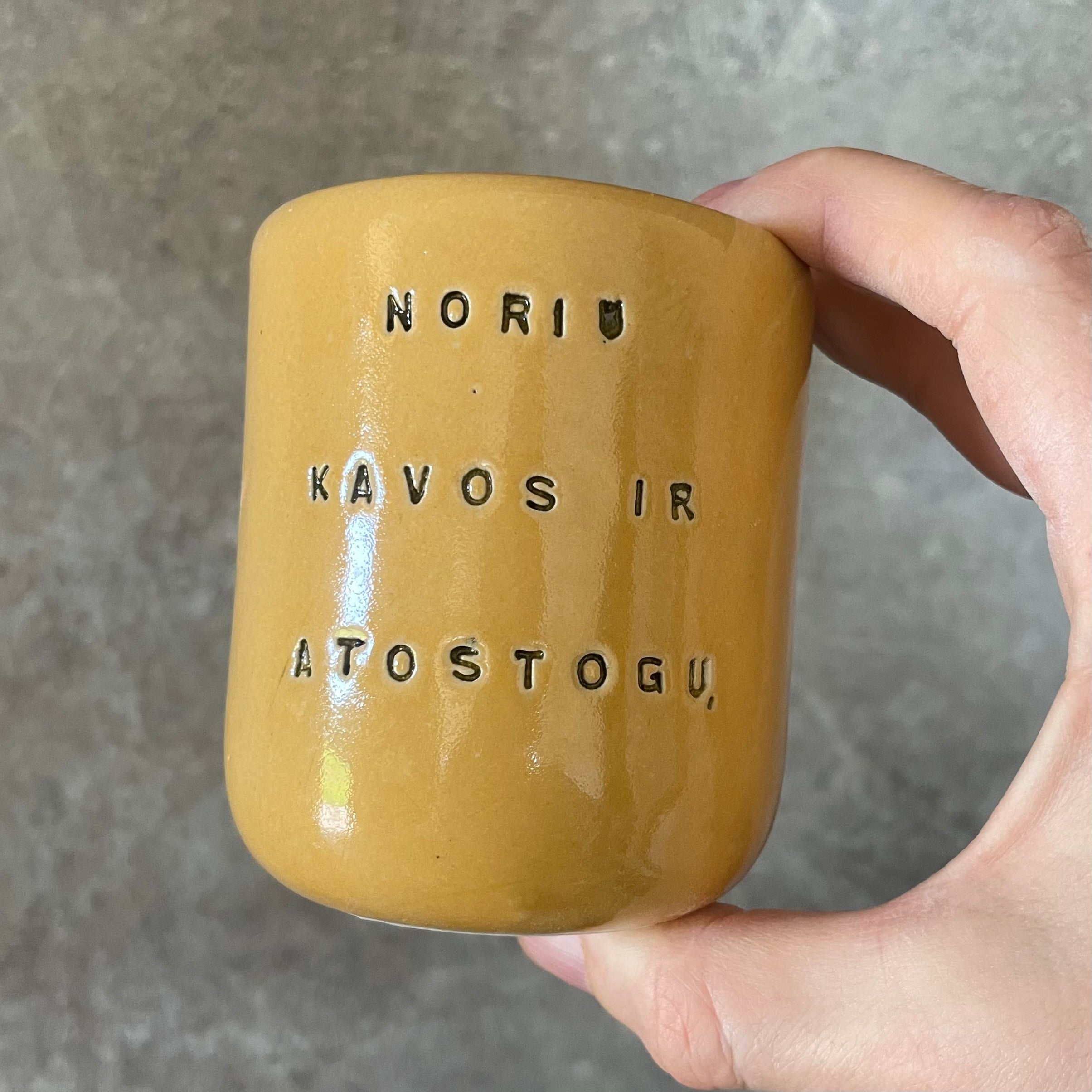 Geltonas mažas puodelis apie kavą ir atostogas
