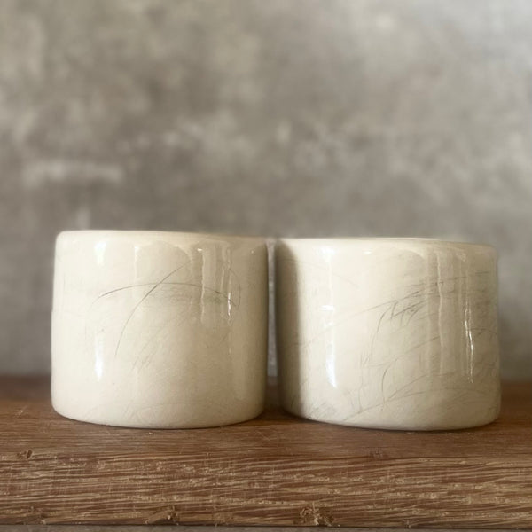 A set of small mugs with words in Lithuanian