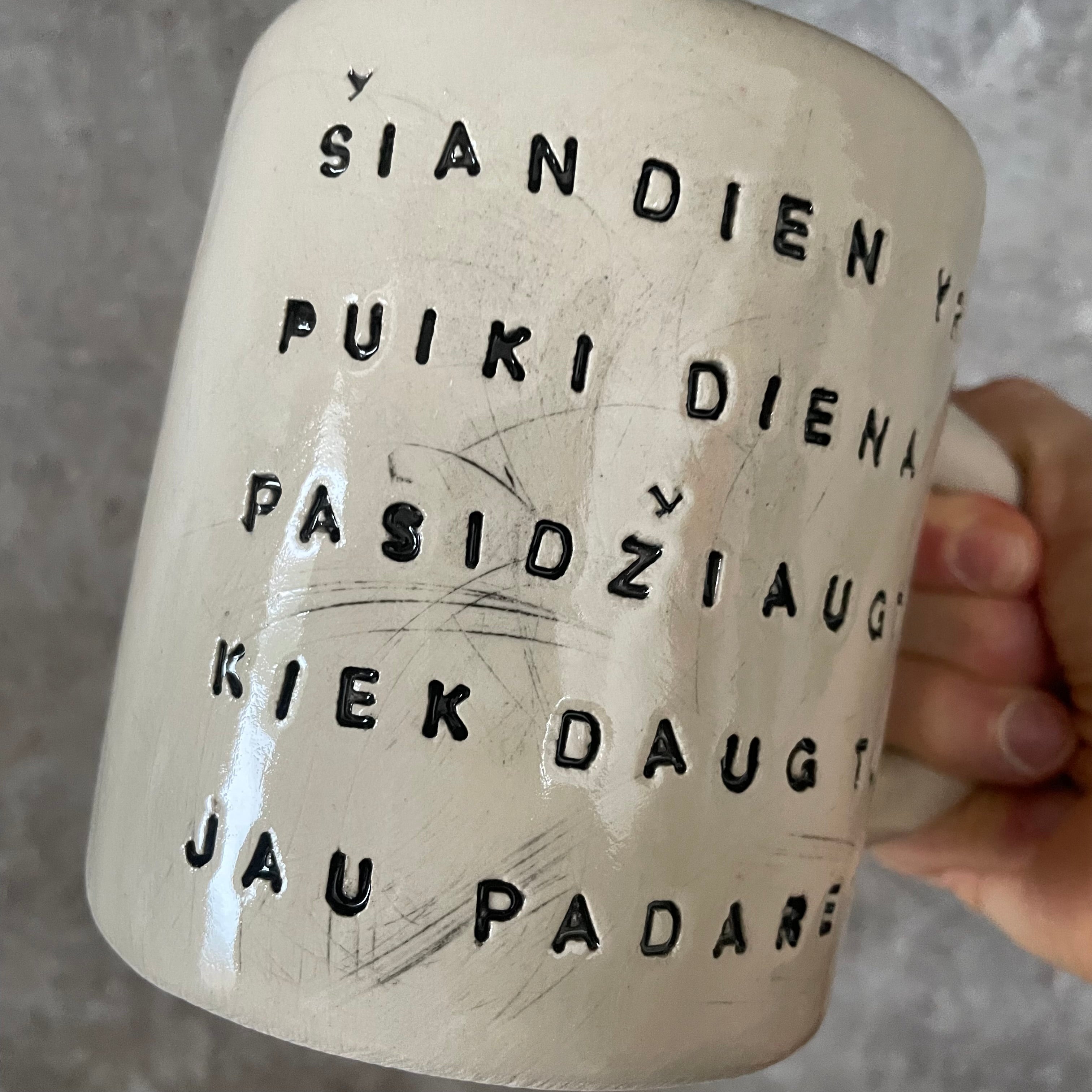 Puodelis su optimistiniu užrašu