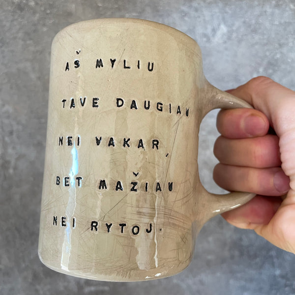 Rusvas puodelis su užrašu apie meilę