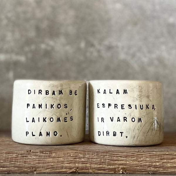 Du maži espresso puodeliai su tekstu apie darbą