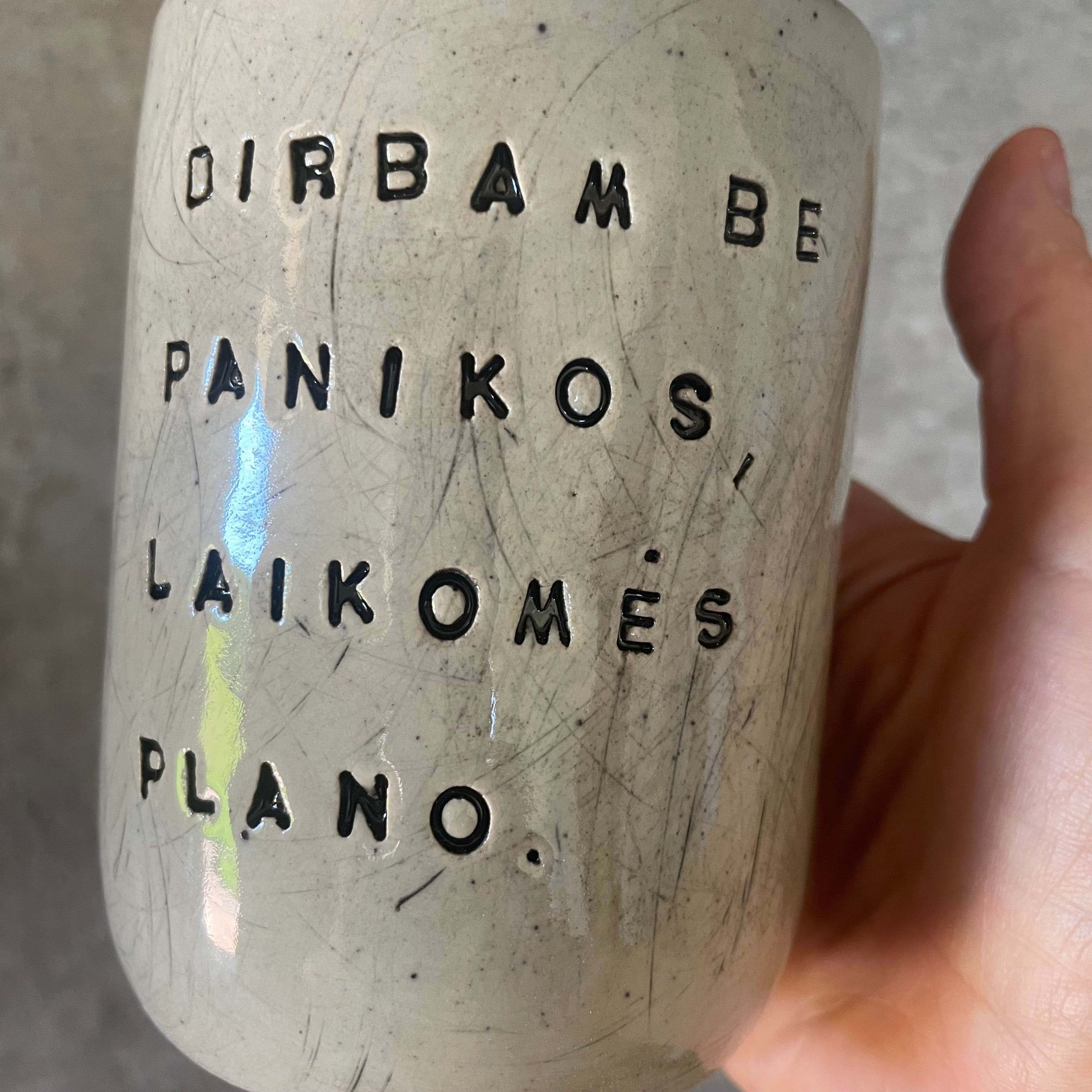 Taškuotas puodelis be rankenos apie darbą