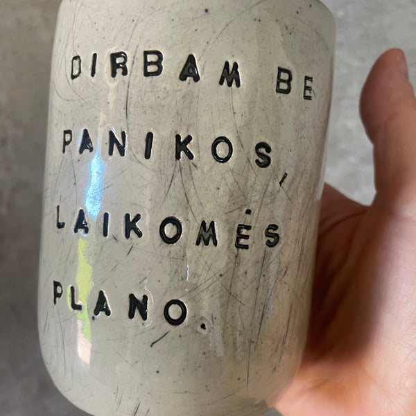 Taškuotas puodelis be rankenos apie darbą