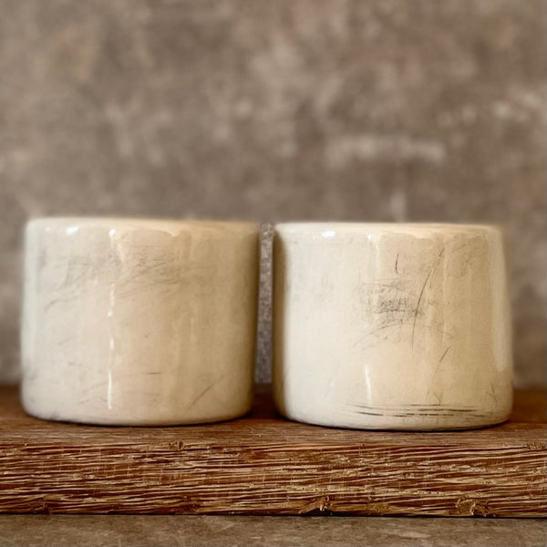 Du maži espresso puodeliai su tekstu apie darbą