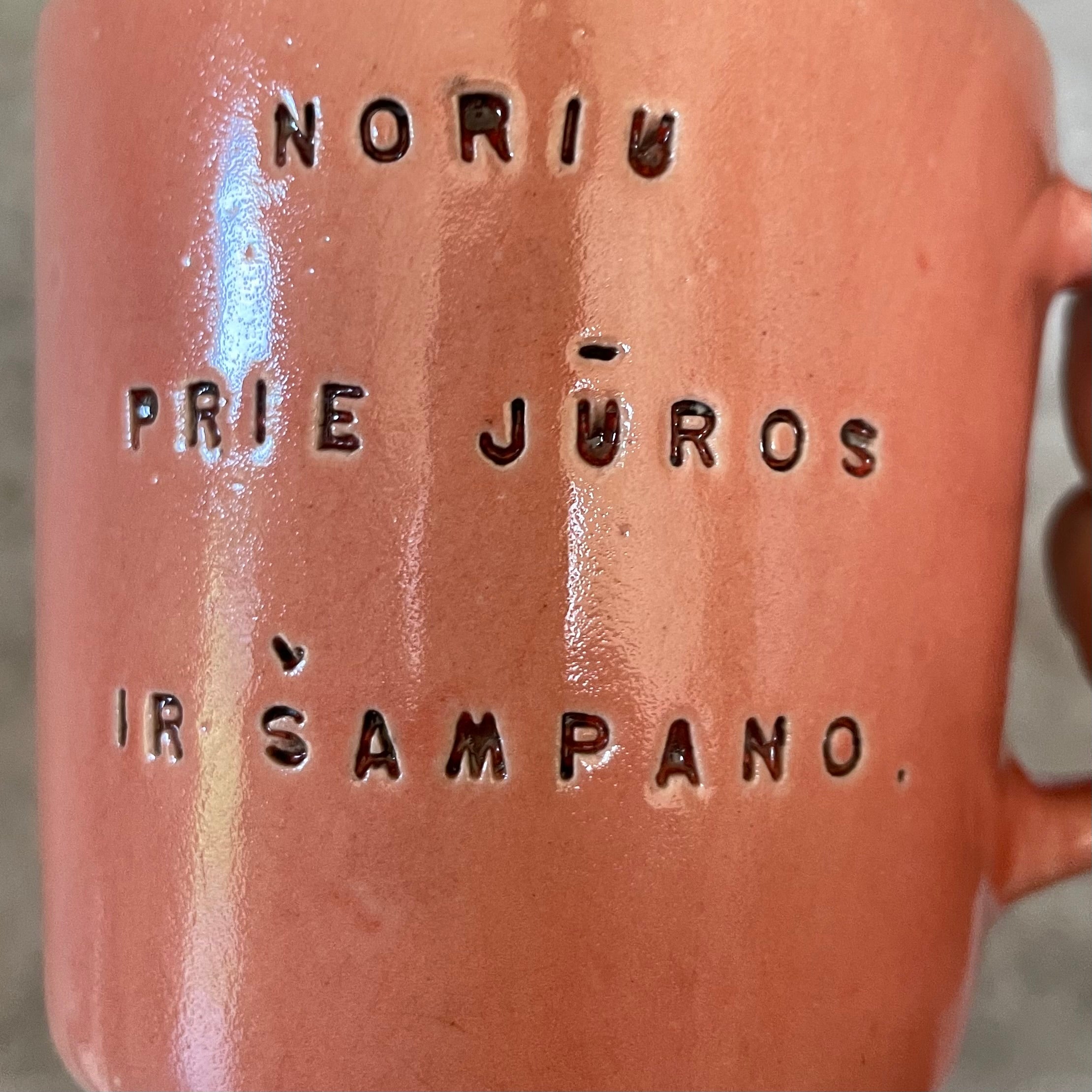 Puodelis su užrašu apie šampaną