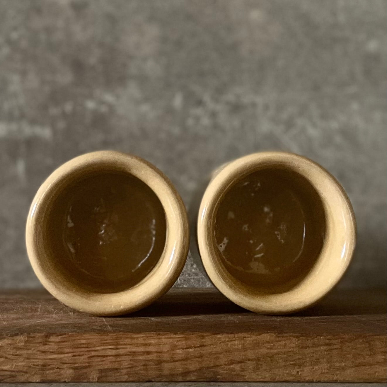 A pair of small mugs with words in Lithuanian