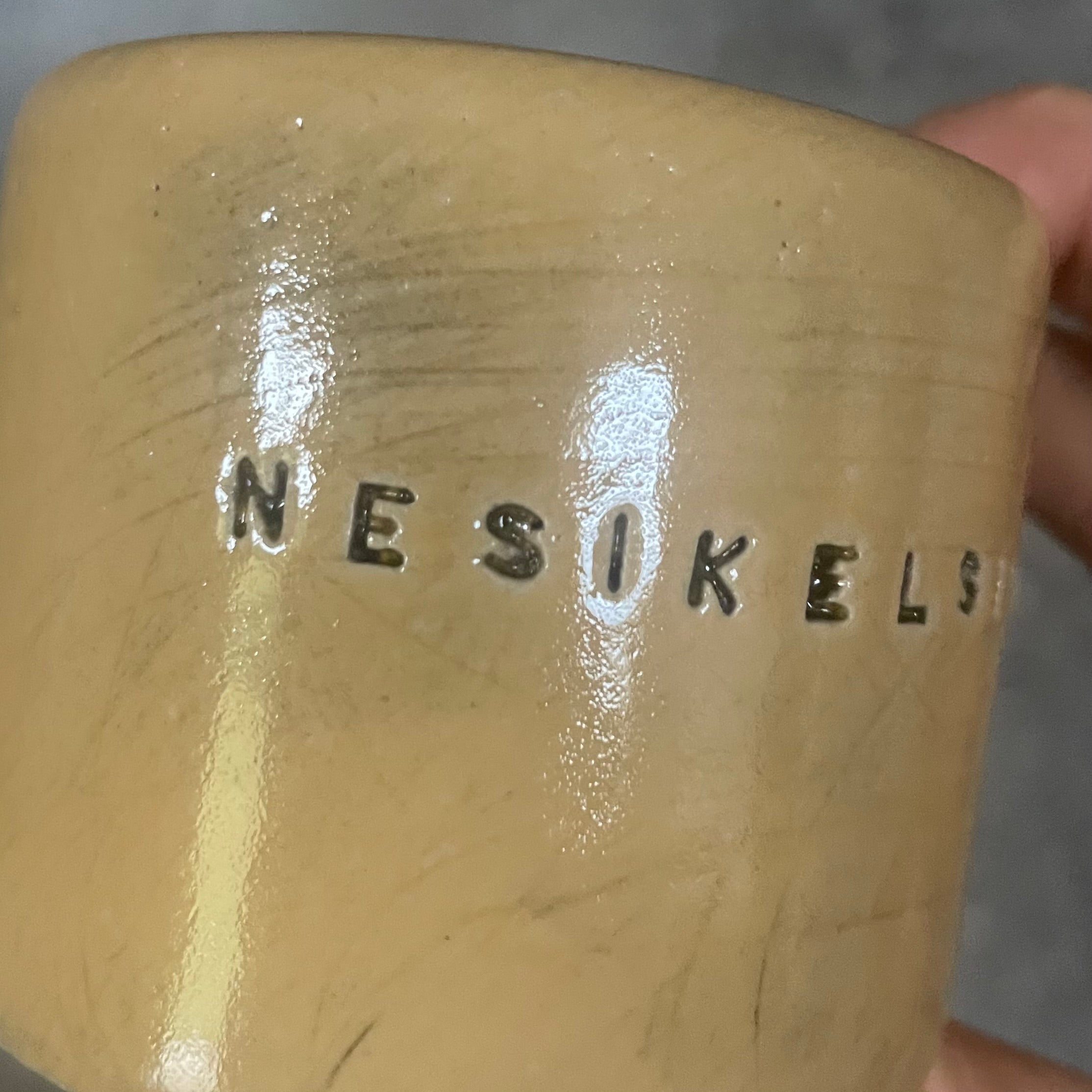 A pair of small mugs with words in Lithuanian