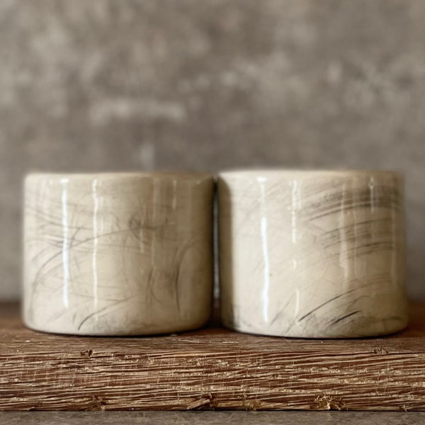 A set of small mugs with words in Lithuanian